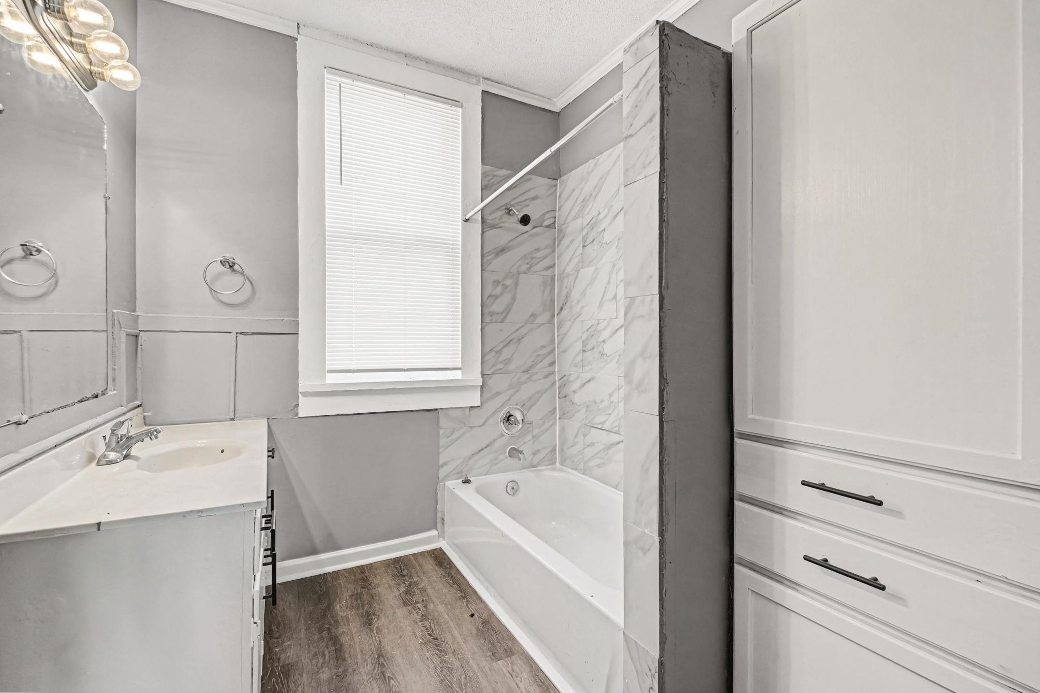 320 North High Street Covington, TN 38019 - Photo 16 of 32 a bathroom with a tub sink and mirror