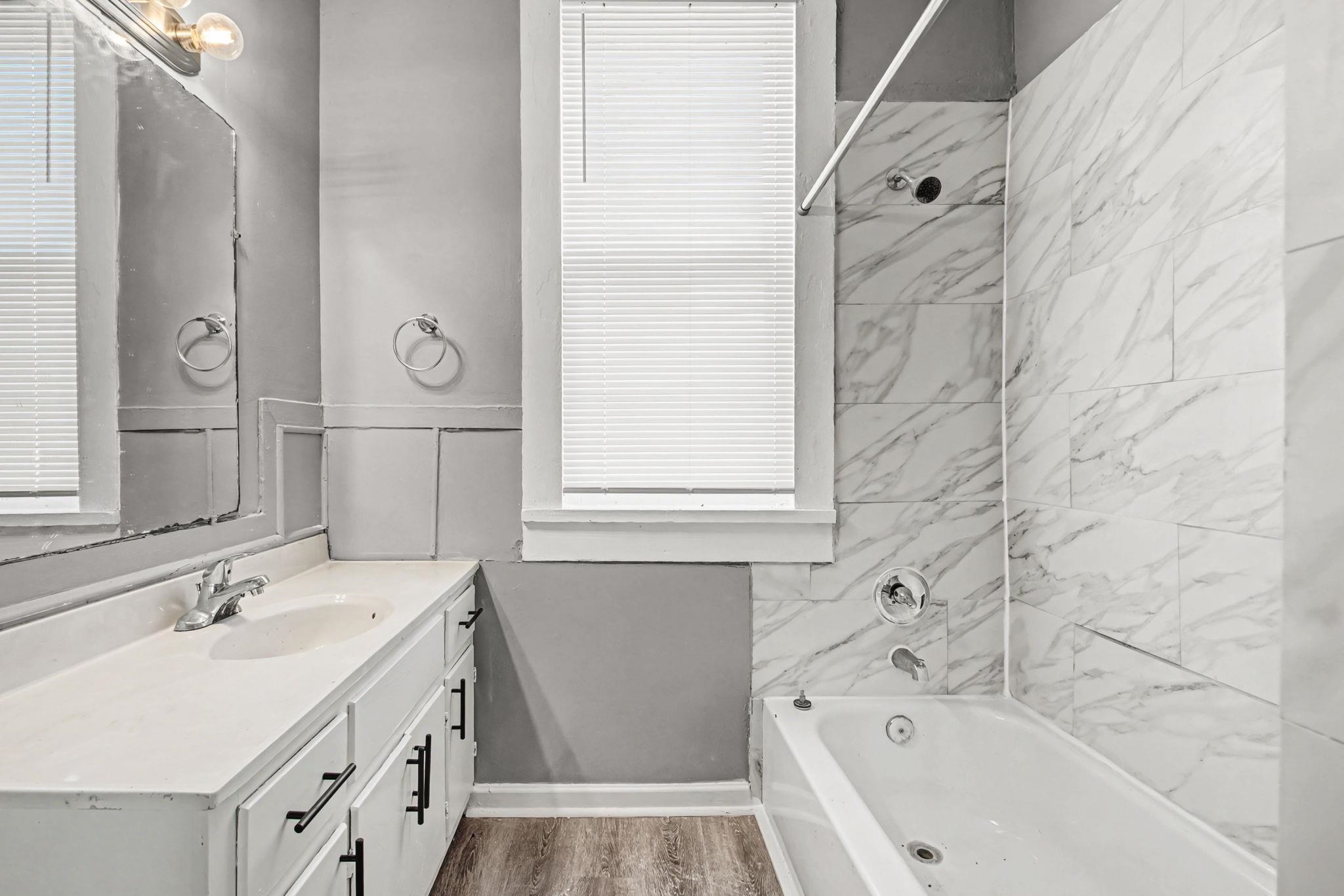 320 North High Street Covington, TN 38019 - Photo 17 of 32 a bathroom with a tub sink and mirror