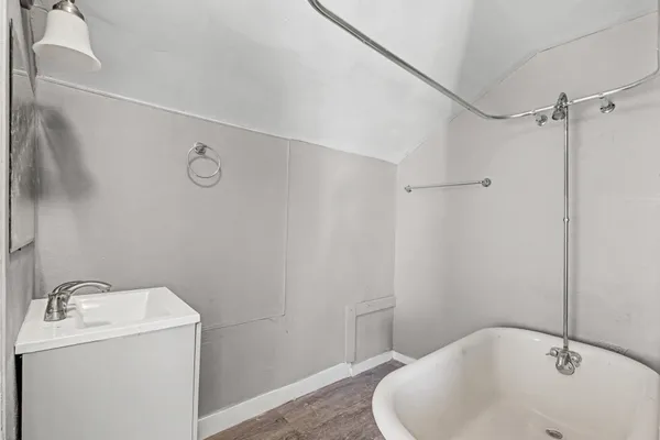 a view of a backyard with large trees plants and wooden fence