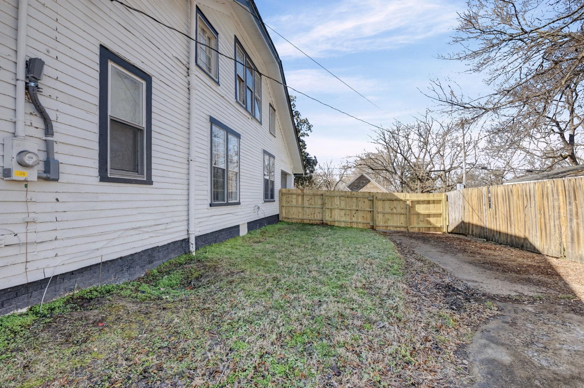 320 North High Street Covington, TN 38019 - Photo 20 of 32 a view of a backyard with large trees plants and wooden fence