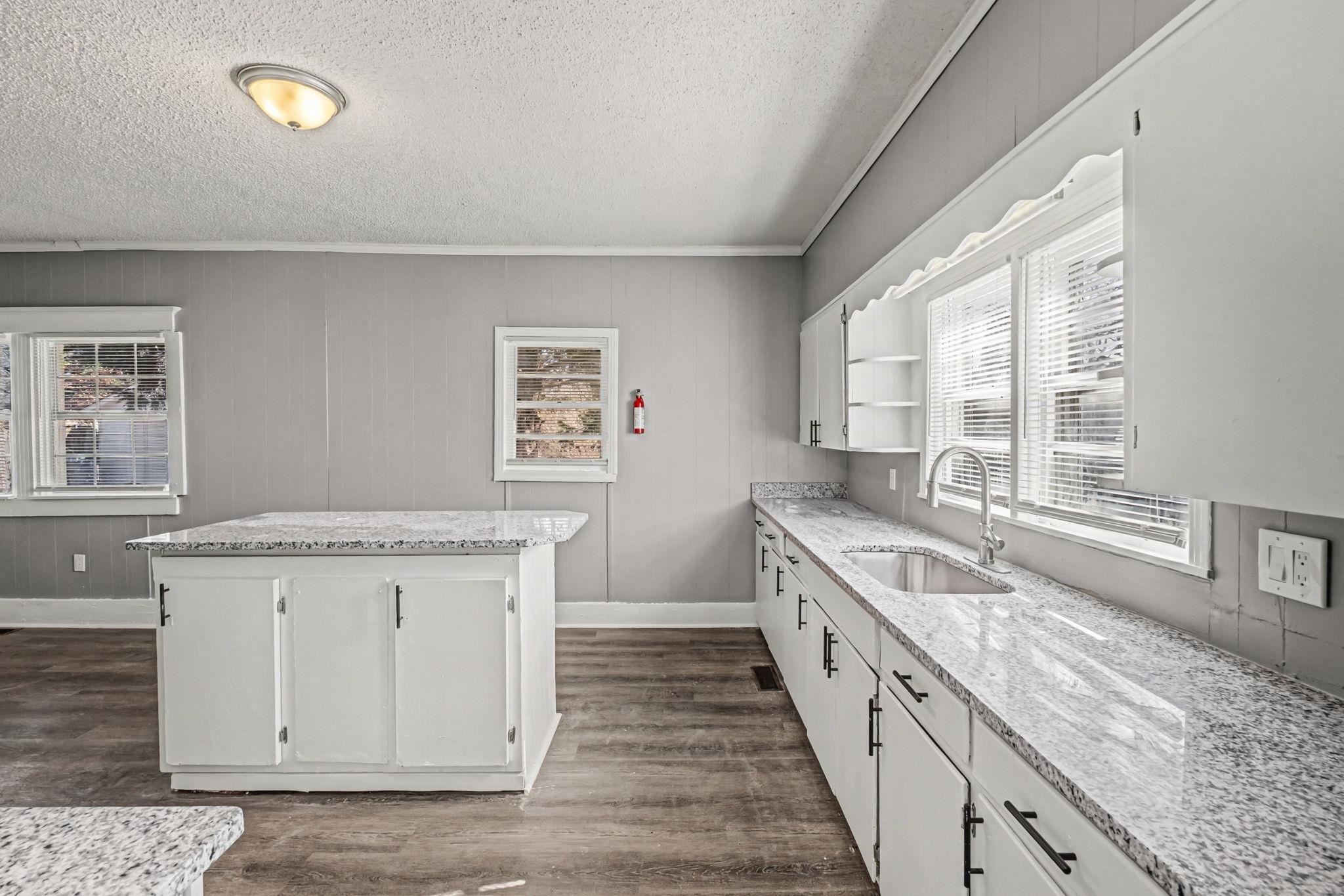 320 North High Street Covington, TN 38019 - Photo 28 of 32 a kitchen with granite countertop a sink stove and cabinets