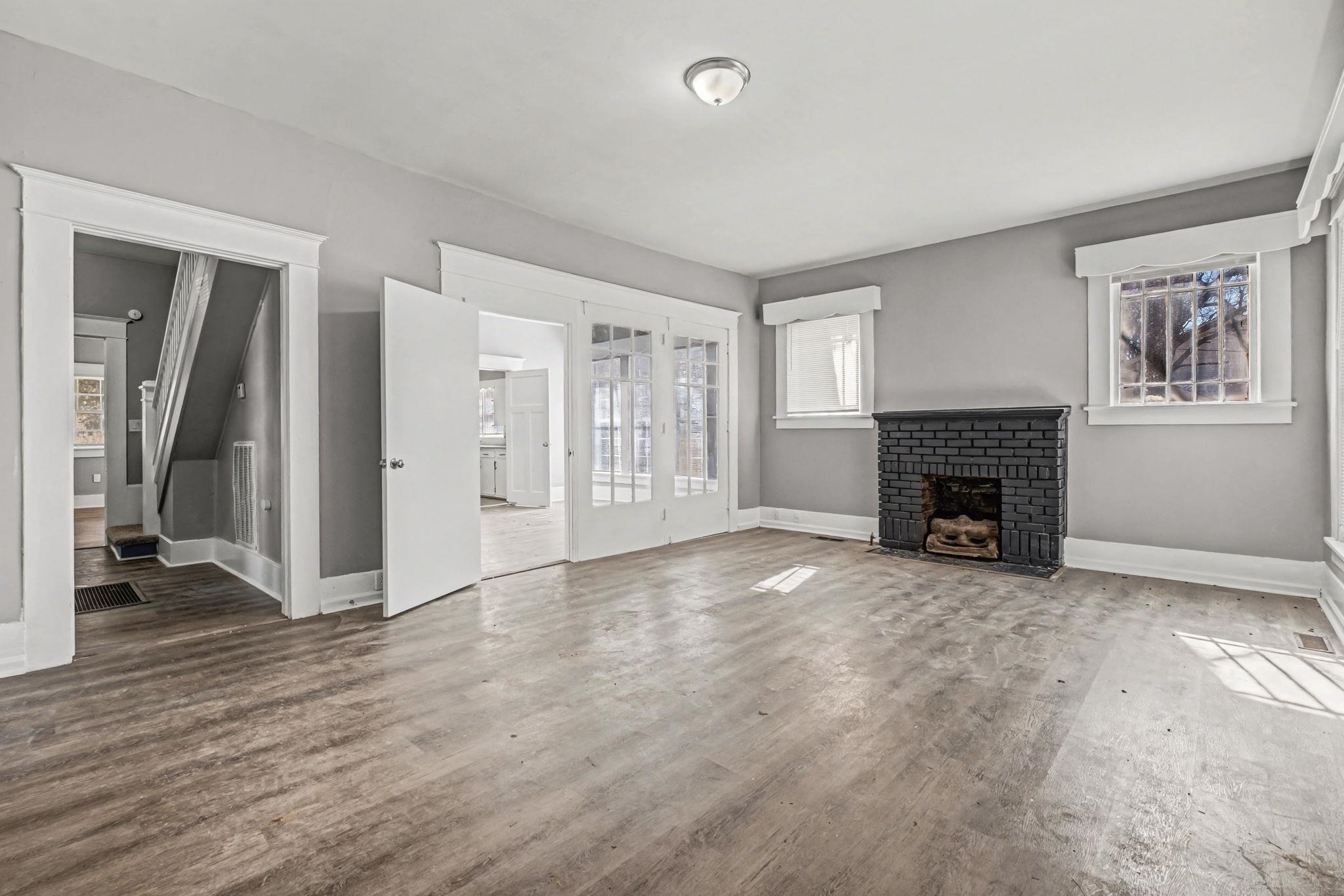 320 North High Street Covington, TN 38019 - Photo 6 of 32 an empty room with windows and a fireplace