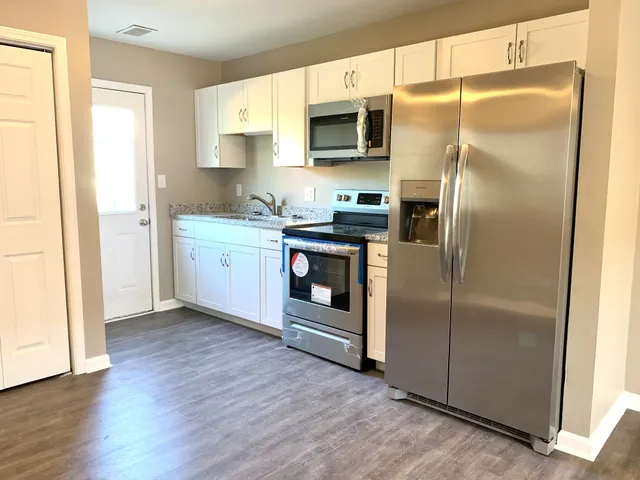 a kitchen with stainless steel appliances granite countertop a refrigerator and a stove top oven