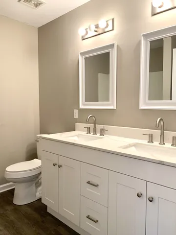 a bathroom with a toilet sink and mirror