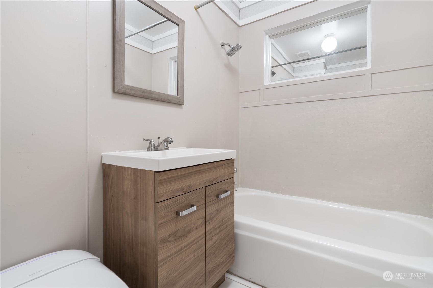 11632 24th Avenue South Seattle, WA 98168 - Photo 24 of 38 a bathroom with a sink mirror vanity and toilet