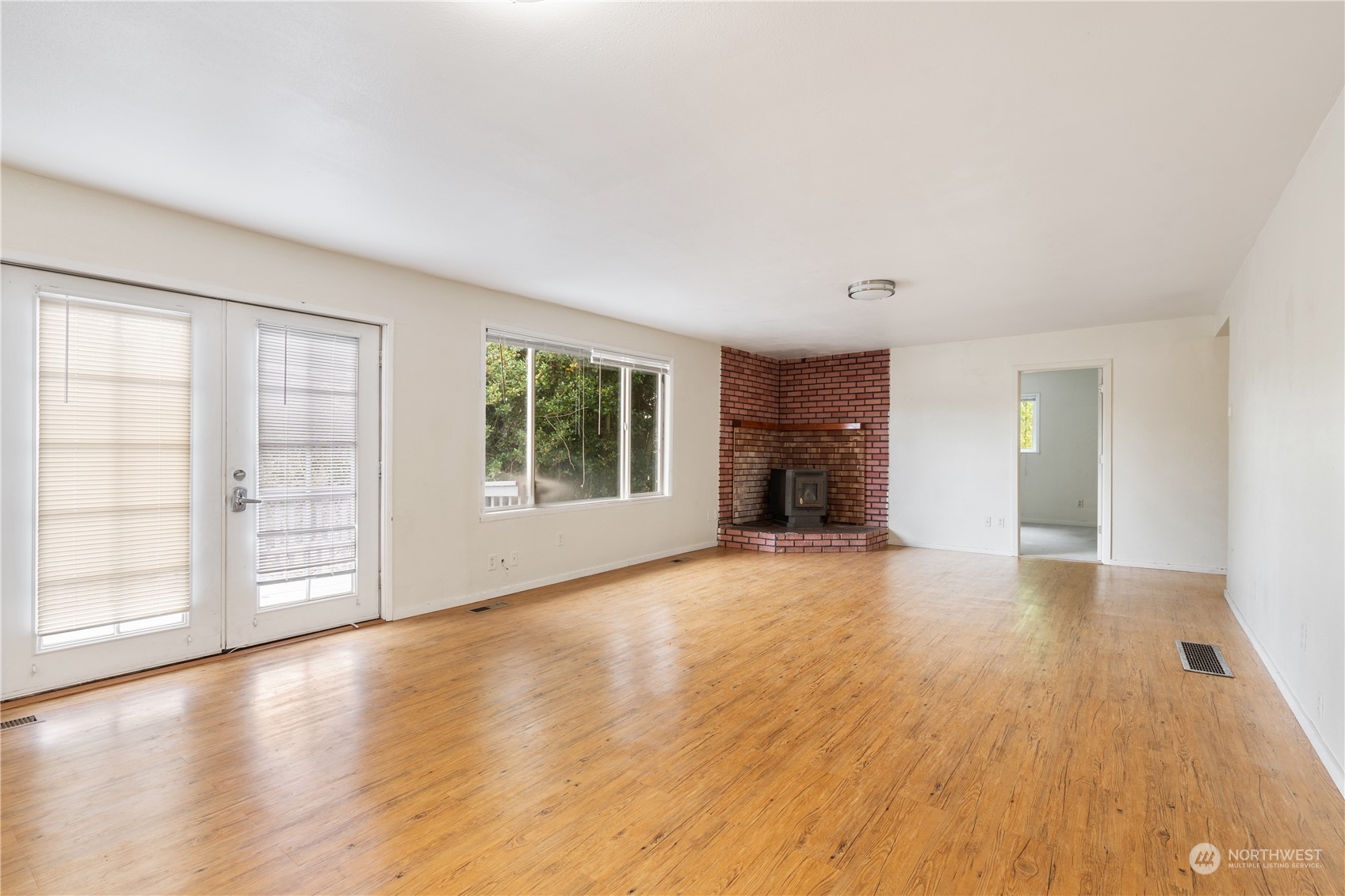 11632 24th Avenue South Seattle, WA 98168 - Photo 7 of 38 a view of an empty room with a window and wooden floor
