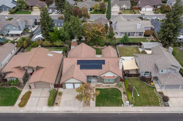 an aerial view of residential houses with outdoor space and parking