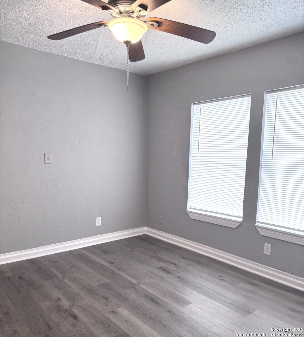 403 Terrell Avenue, Unit 2 San Antonio, TX 78214 - Photo 4 of 12 an empty room with wooden floor and windows