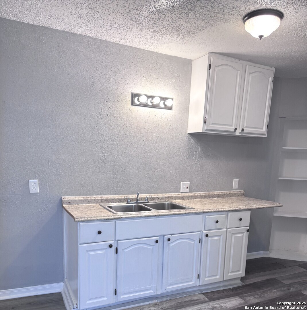 403 Terrell Avenue, Unit 2 San Antonio, TX 78214 - Photo 8 of 12 a sink with granite countertop white cabinets