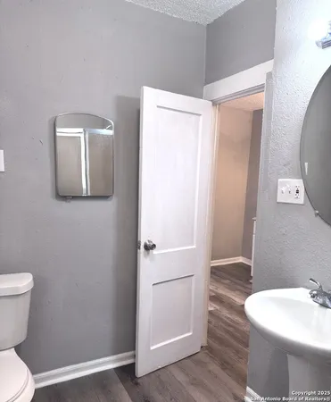 a bathroom with a toilet sink and mirror