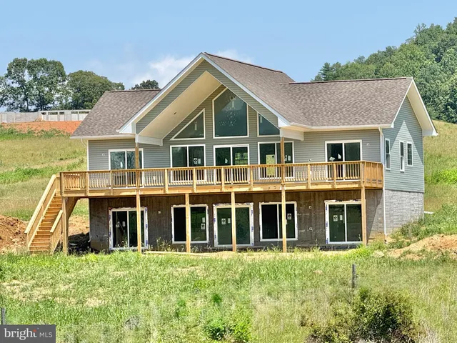 an empty room with wooden floor fireplace and windows