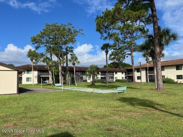 1515 Huntington Lane, Unit 128 Rockledge, FL 32955 - Photo 5 of 7 a front view of a building with a garden