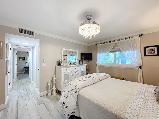 a bedroom with a bed and a chandelier