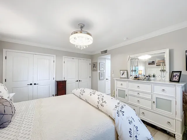 a spacious bedroom with a bed and a chandelier
