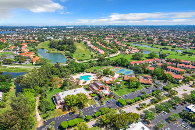 an aerial view of residential houses with outdoor space and trees