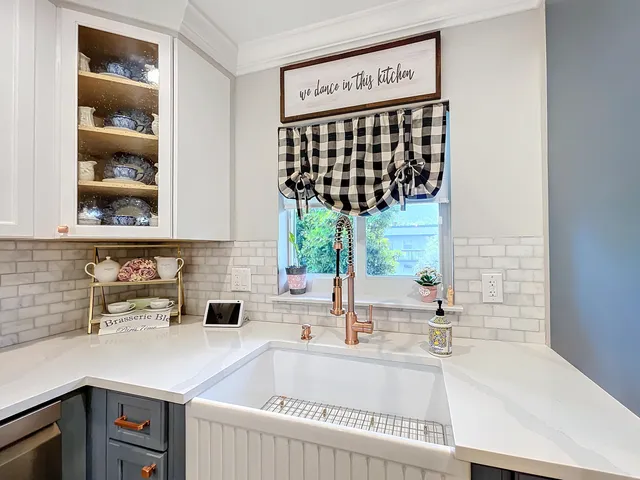a kitchen with a sink and a stove next to a white cabinet