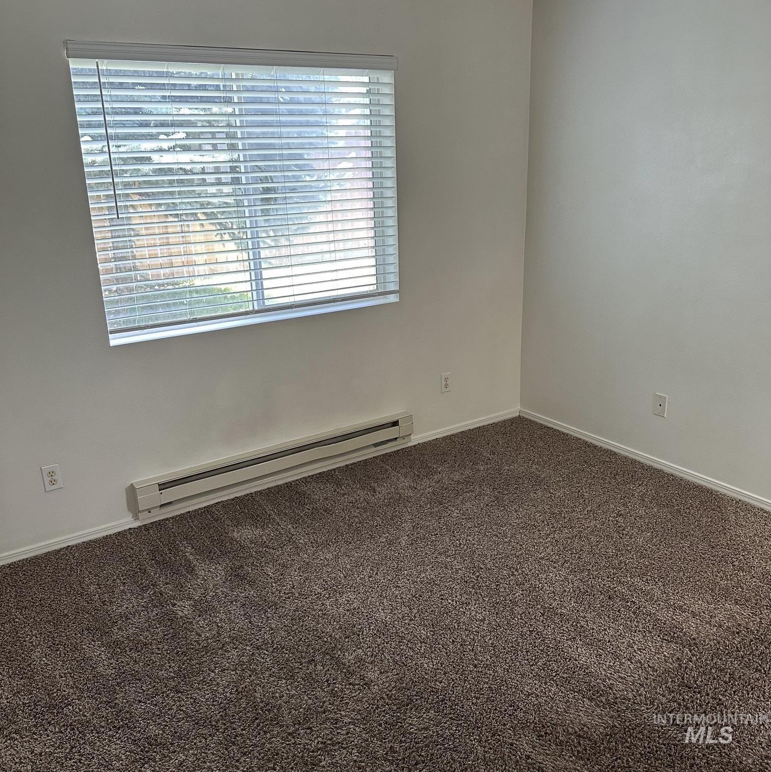2140 Elizabeth Boulevard Twin Falls, ID 83301 - Photo 6 of 18 Empty room featuring dark colored carpet and a baseboard heating unit