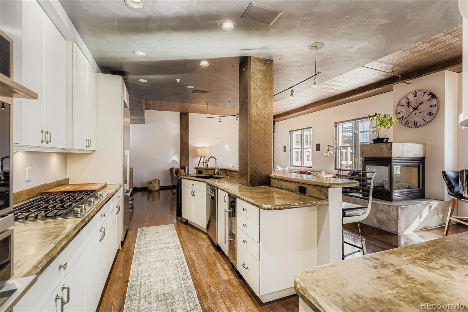 1735 19th Street, Unit 5B Denver, CO 80202 - Photo 15 of 50 a kitchen with stainless steel appliances granite countertop a stove top oven a sink a counter space and cabinets