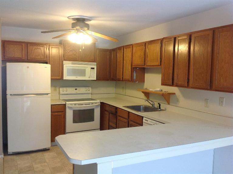 11 Round House Road, Unit 11 Bourne, MA 02532 - Photo 18 of 23 a kitchen with stainless steel appliances granite countertop a refrigerator a sink dishwasher a stove with wooden cabinets