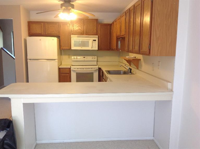 11 Round House Road, Unit 11 Bourne, MA 02532 - Photo 22 of 23 a kitchen with stainless steel appliances granite countertop a sink a stove and a refrigerator with wooden floor