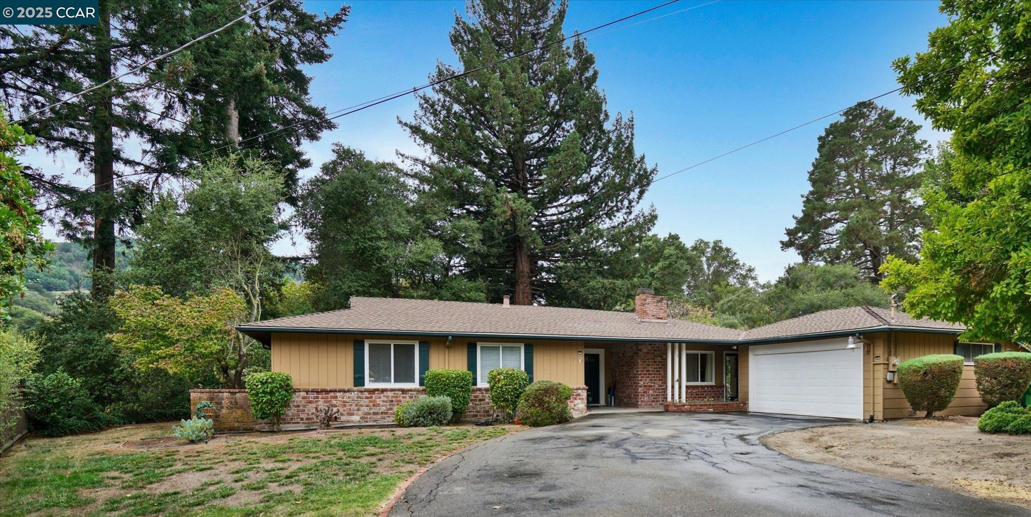 Del Rey-Moraga Del Ray Orinda, CA 94563 - Photo 1 of 1 a view of a yard in front of a house with plants and large tree