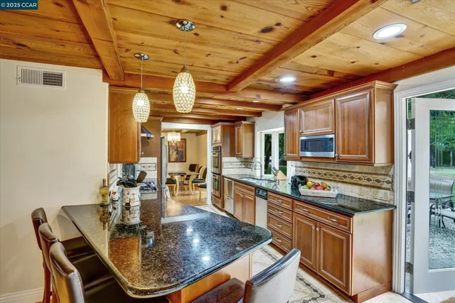 a kitchen with stainless steel appliances granite countertop a stove a sink and a refrigerator