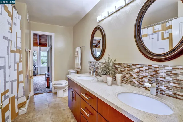 a bathroom with a granite countertop toilet a sink and a mirror