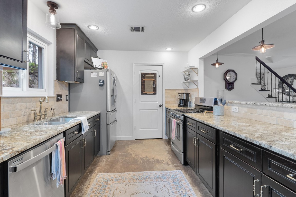1808 Chincoteague Way Round Rock, TX 78681 - Photo 11 of 40 a large kitchen with stainless steel appliances granite countertop a sink stove and refrigerator