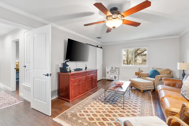 a living room with furniture two wooden floor and a ceiling fan