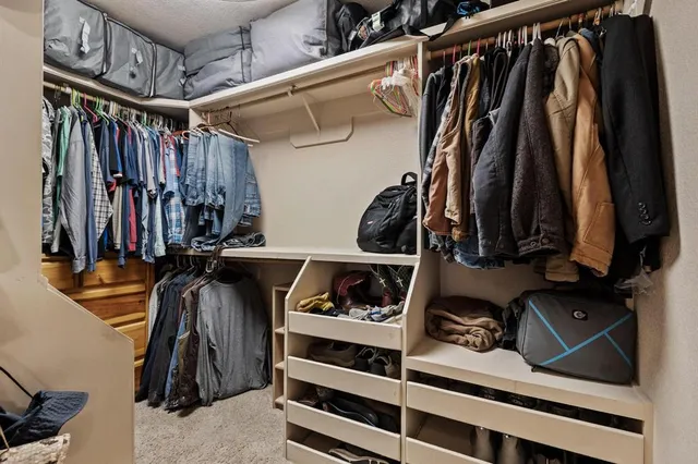 a view of walk in closet with clothes and shoes