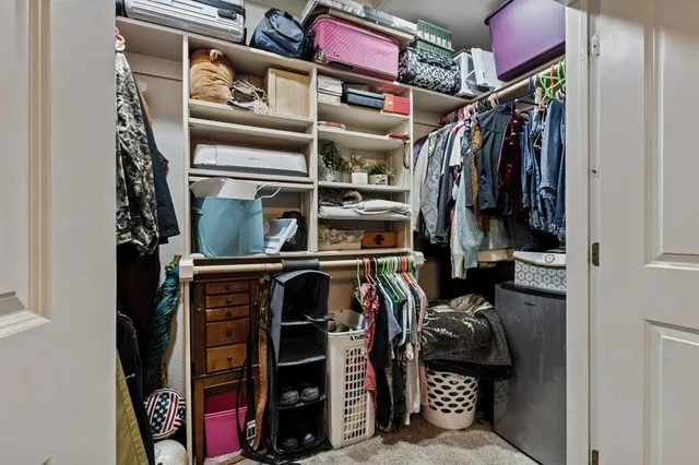 a view of walk in closet with clothes and shoes