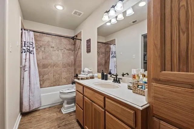a bathroom with a double vanity sink mirror and toilet