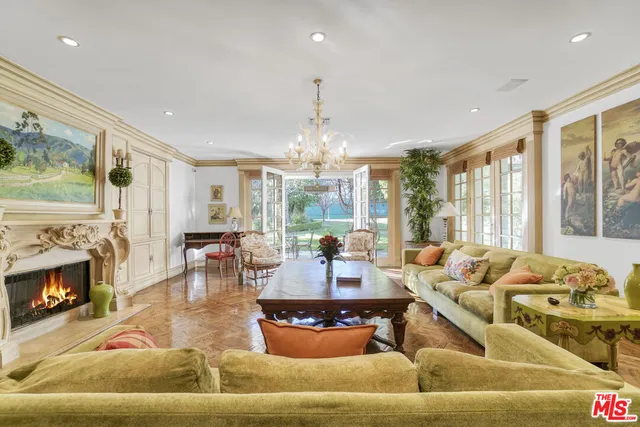 a living room with furniture fireplace and large windows