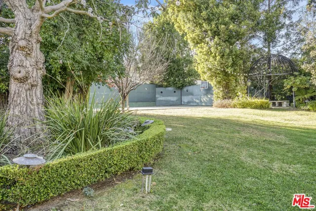 a view of a big yard with large trees