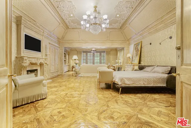 a spacious bedroom with a bed and a flat screen tv