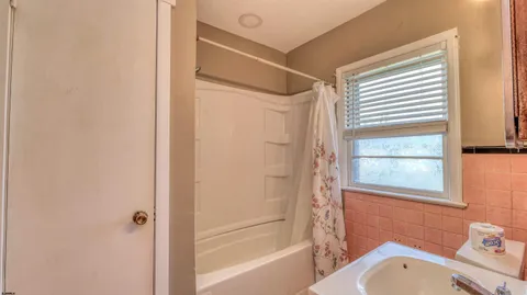 a bathroom with a granite countertop window toilet and a bathtub