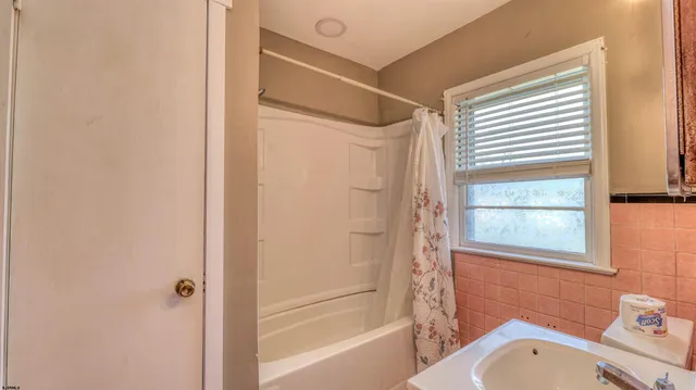 a bathroom with a granite countertop window toilet and a bathtub
