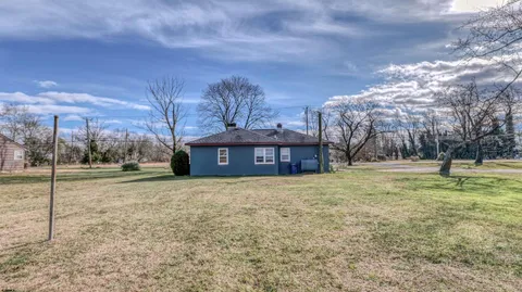a view of a large house with a big yard and large trees