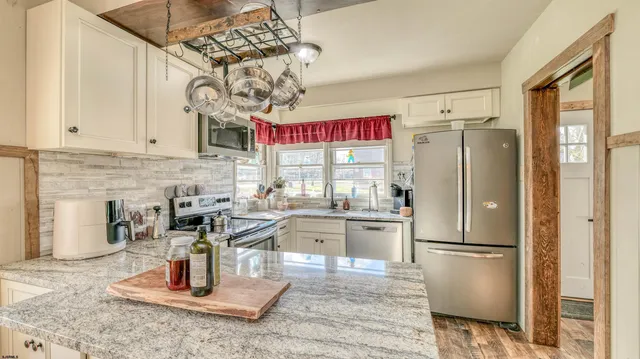 a kitchen with stainless steel appliances granite countertop a refrigerator and a sink