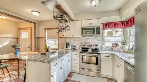 a kitchen with stainless steel appliances granite countertop a stove and cabinets