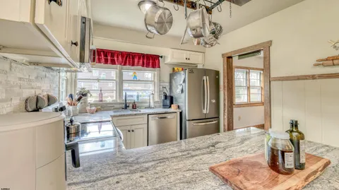 a kitchen with stainless steel appliances kitchen island granite countertop a refrigerator and stove