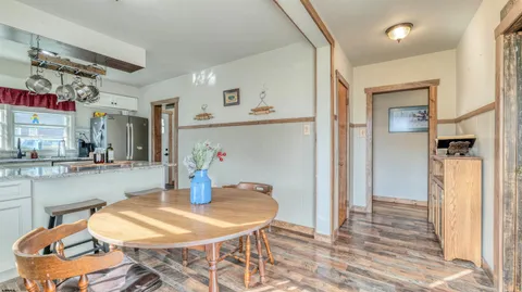 a kitchen with stainless steel appliances kitchen island granite countertop a table and chairs in it