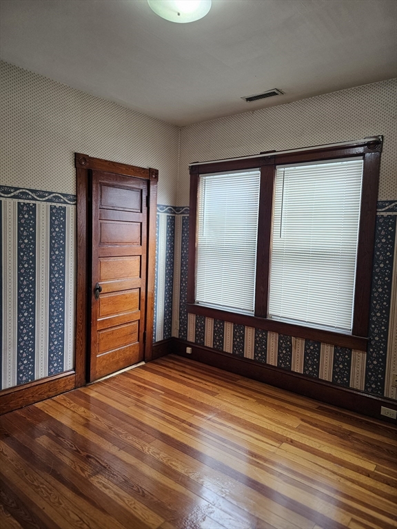 404 Stevens Street, Unit 2 Lowell, MA 01851 - Photo 9 of 12 a view of an empty room with wooden floor and a window