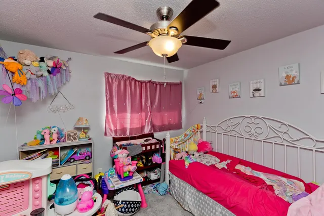 a bedroom with baby toys and flat tv screen