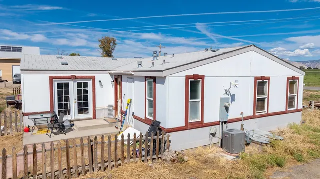 a view of a patio with a table and chairs and wooden fence