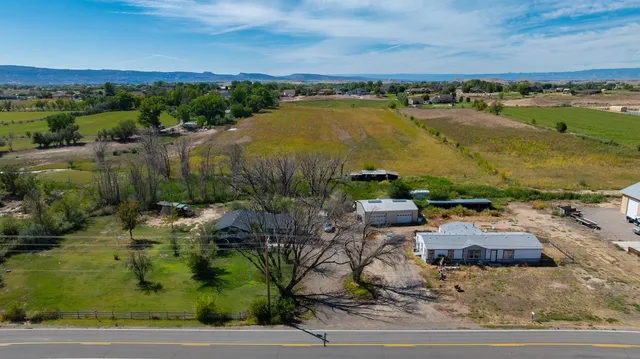 an aerial view of residential houses with outdoor space and lake view