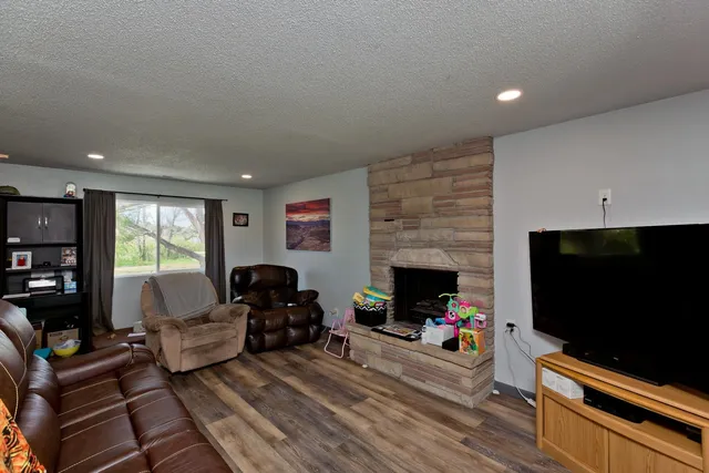 a living room with furniture a flat screen tv and a fireplace