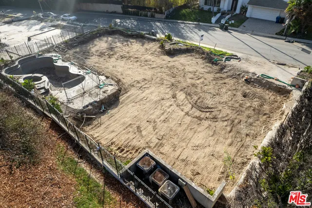 a view of a backyard with wooden fence