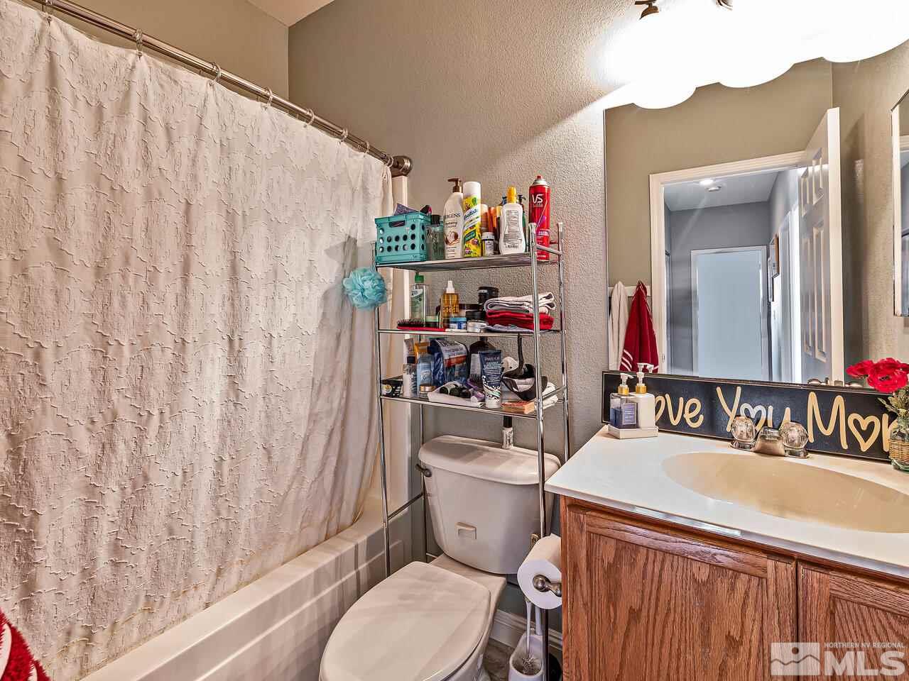 2289 Rio Lobo Lane Reno, NV 89521 - Photo 12 of 17 a bathroom with a sink a toilet and a mirror