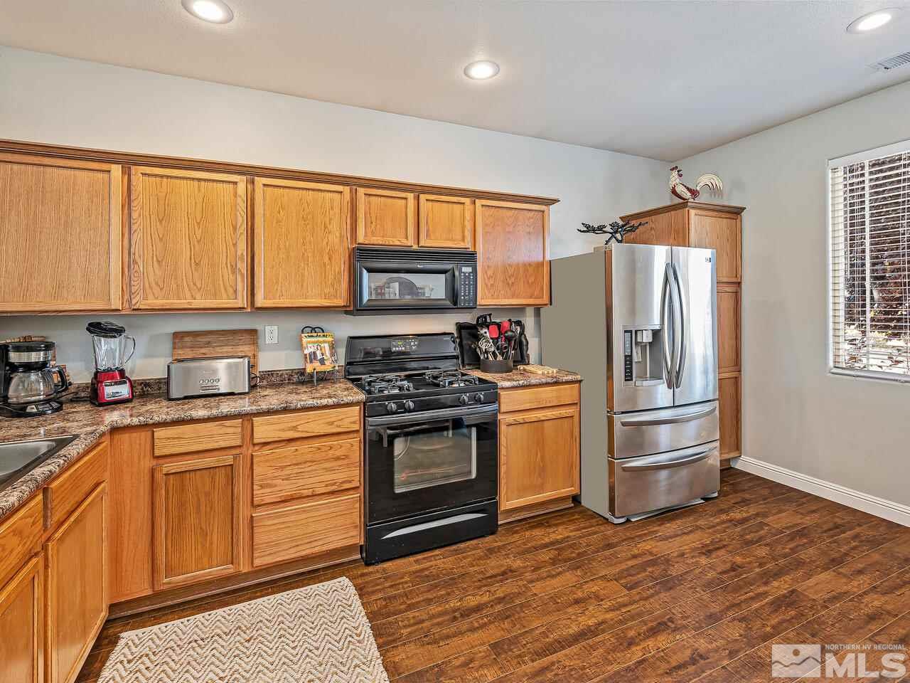 2289 Rio Lobo Lane Reno, NV 89521 - Photo 3 of 17 a kitchen with stainless steel appliances granite countertop a refrigerator a stove a sink and a microwave